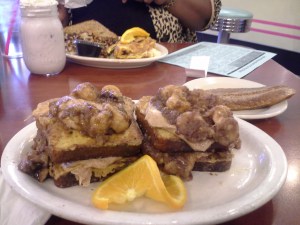 French toast, made with gluten-free bread, smothered in cinnamon sauce, cream cheese frosting, and bananas foster
