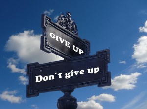 Street signs depicting the corner of "Don't give up" and "Give up."  By geralt on Pixabay at https://pixabay.com/en/road-sign-shield-courage-hope-task-940644/