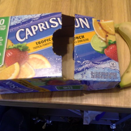 Carton of CapriSun next to a bruised banana