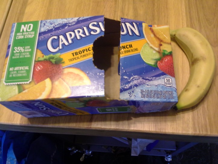 Carton of CapriSun next to a bruised banana
