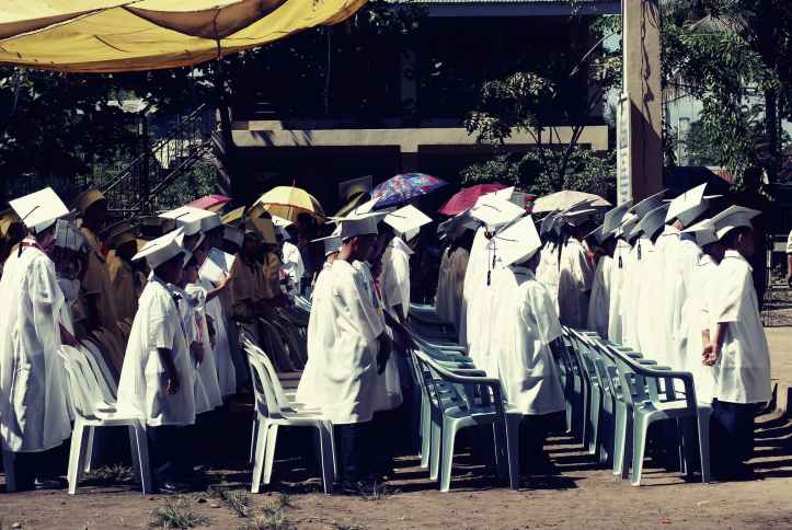 children wearing white academic gown during graduation ceremony at daytime